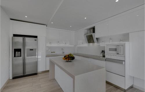 a white kitchen with a counter and a refrigerator at Villa Prestige in Baška Voda