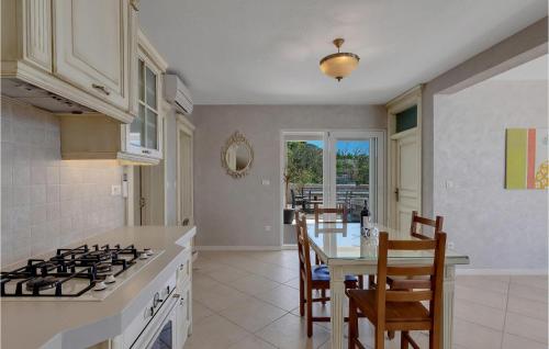 a kitchen with a stove and a table with chairs at Villa Prestige in Baška Voda