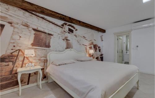 a bedroom with a white bed and a brick wall at Villa Prestige in Baška Voda