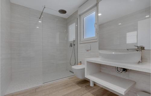 a white bathroom with a sink and a toilet at Villa Prestige in Baška Voda