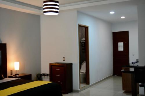 a bedroom with a bed and a dresser and a mirror at Suites La Gloria Alojamiento independiente in Tepatitlán de Morelos