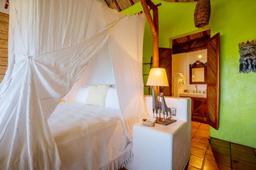 a bedroom with a bed with a mosquito net at Ensueño de Fuga in Zihuatanejo