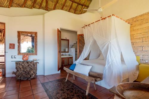a bedroom with a bed with a mosquito net at Ensueño de Fuga in Zihuatanejo