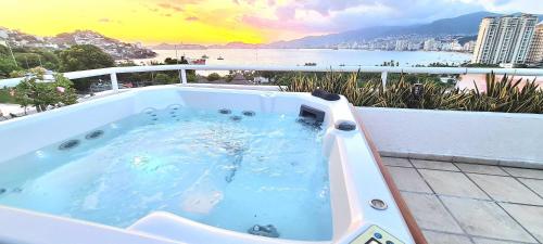 a hot tub on a balcony with a view of the ocean at Penthouse en Las Brisas Acapulco in Acapulco