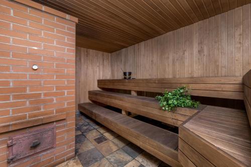 a wooden sauna with a plant in a brick wall at Woodland Retreat Lodge in Vallapalu