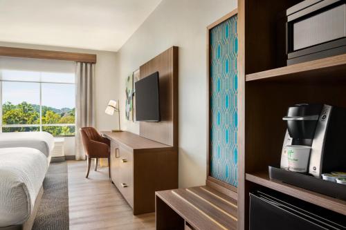 a hotel room with a bed and a tv at Holiday Inn Birmingham - Hoover by IHG in Hoover