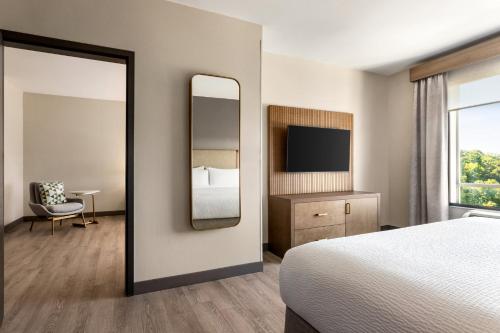 a hotel room with a bed and a mirror at Holiday Inn Birmingham - Hoover by IHG in Hoover