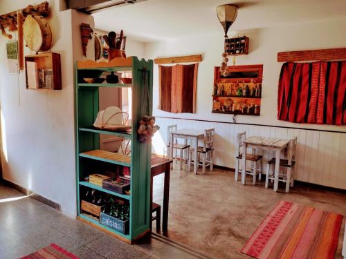 a room with a green cabinet and a dining room at La Colorada Hostal in Tilcara