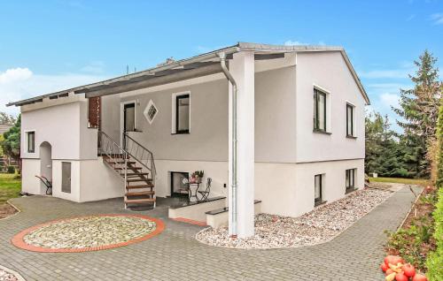 a white house with a spiral staircase in a yard at Ferienwohnung Vogelsang-Warsin in Vogelsang