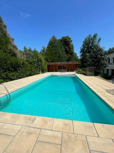 une piscine bleue avec une terrasse en bois et un bâtiment dans l'établissement appartement avec terrasse, à Sillery
