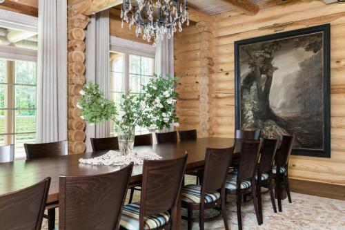 a dining room with a table and chairs and a painting at Woodland Retreat Lodge in Vallapalu