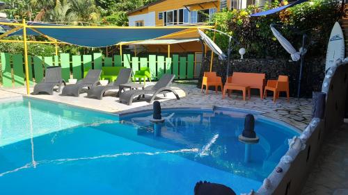 a swimming pool with a bunch of chairs and a table at Fare Arana Mooréa Guesthouse in Atiha