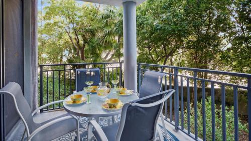 a table with glasses of wine on a balcony at Conch in the Treetops by Last Key Realty in Key West