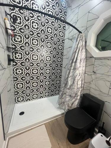 a bathroom with a shower with a black toilet at Cottage close it the Lake in Somerset