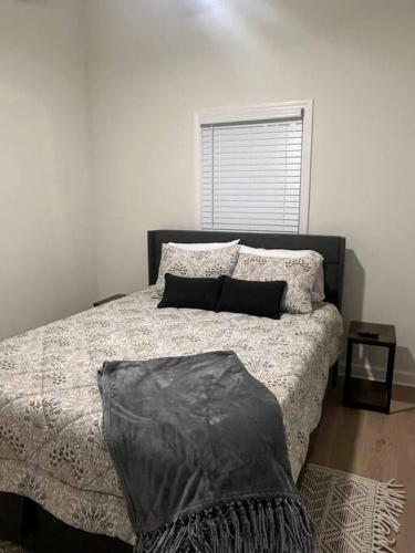 a bedroom with a bed with a black and white comforter at Cottage close it the Lake in Somerset