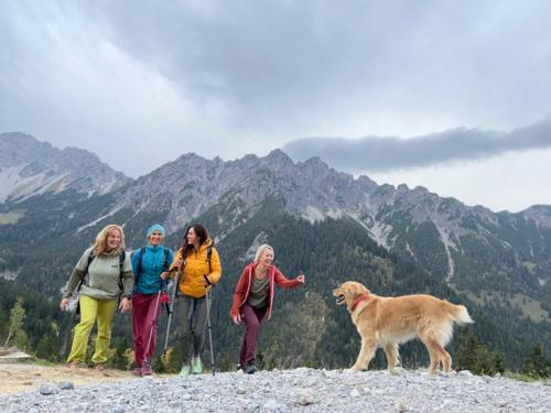 a group of people standing on a mountain with a dog at Sonnes Apartment in Andelsbuch