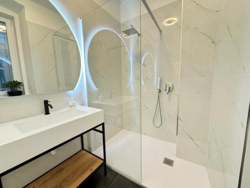 a white bathroom with a sink and a shower at Boutique Apartment Trieste in Trieste