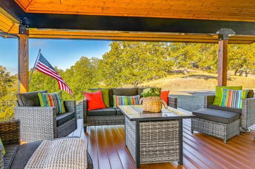 an outdoor patio with wicker furniture and an american flag at Dreamy Hilltop View Roseburg Wine Country Retreat in Roseburg
