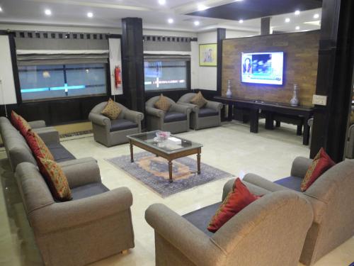 a large living room with couches and a piano at City Centre Suites in Multan