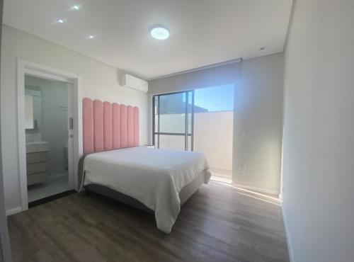 a bedroom with a bed and a large window at Apto mobiliado em Balneário Piçarras 100 m do mar in Piçarras