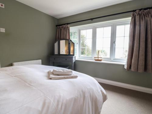 a bedroom with a white bed and a window at Fairview House in Seaton
