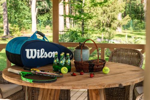 a table with a bag and tennis balls on it at Woodland Retreat Lodge in Vallapalu