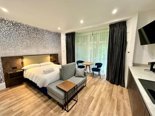 a hotel room with a bed and a table and chairs at Rhode Lane - Serviced Apartments Bridgwater in Bridgwater
