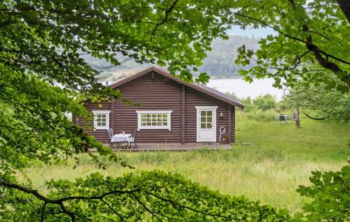 a log cabin in the middle of a field at 2 Bedroom Cozy Home In Mariager in Mariager