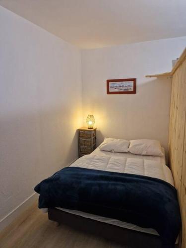 - une chambre avec un lit dans un dortoir doté d'une lampe dans l'établissement Appartement studio Pompon, Wifi, 2 couchages, charme, centre historique, à La Rochelle