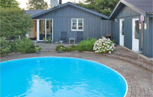 a blue swimming pool in front of a house at Holiday Home Sunds 35 in Sunds