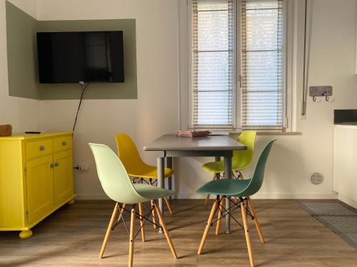 a room with a table and chairs and a tv at Soria Home-A due passi da Centro e Mare in Pesaro