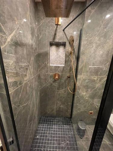La salle de bains est pourvue d'une douche et de carrelage. dans l'établissement Cosy Appart Paris 8e champs elysees Miromesnil, à Paris