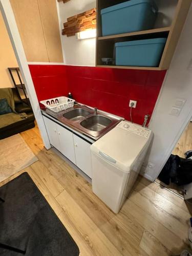 une petite cuisine avec un évier et une machine à laver dans l'établissement Appartement Charleville hyper centre, à Charleville-Mézières