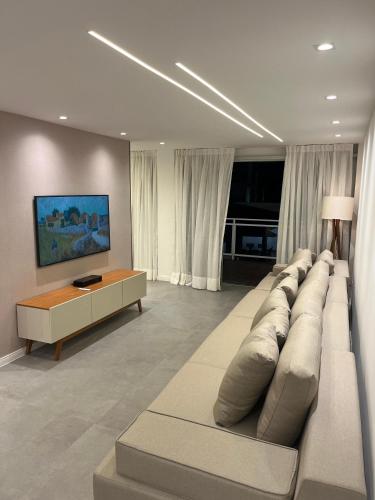 a living room with a large couch and a table at Residence Dunas Exclusive in Natal