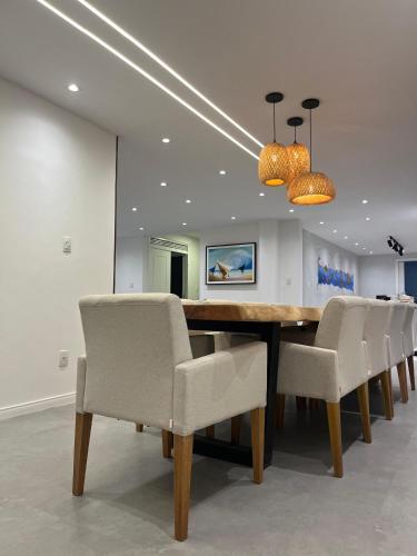a dining room with a wooden table and chairs at Residence Dunas Exclusive in Natal