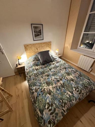 - une chambre avec un lit doté d'une couette et d'un oreiller dans l'établissement Appartement Charleville hyper centre, à Charleville-Mézières