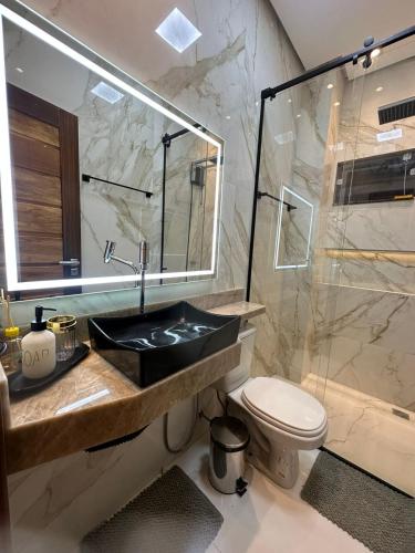 a bathroom with a sink and a shower and a toilet at Apartamento Sofisticado Alter do Chão Ilha Bela Residence in Santarém