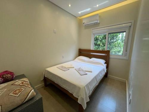 a small bedroom with a bed and a window at Casa Sítio Caminhos Da Serra in Feliz