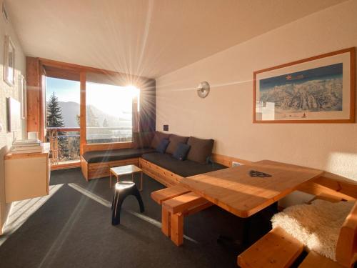 un salon avec un canapé et une table dans l'établissement Appartement Perriand Les Arcs 1800, à Arc 1800
