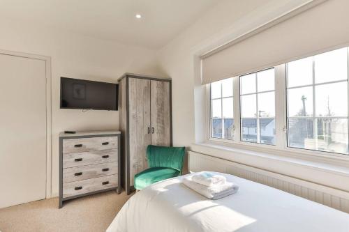 a bedroom with a bed and a green chair at Cosy, Exclusive Sheffield House near Peak district in Sheffield