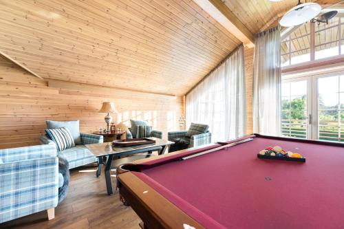 a living room with a pool table in a room at Woodland Retreat Lodge in Vallapalu