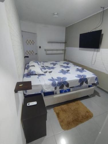 a bedroom with a bed and a flat screen tv at Departamento Yavari in Iquitos