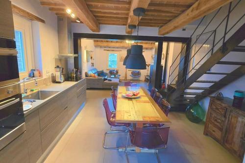 a large kitchen with a wooden table and a staircase at The Cherry House, Apartamento Monterosa in Petritoli