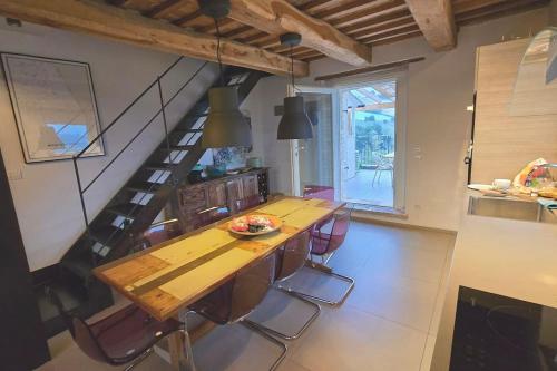 a dining room with a wooden table and chairs at The Cherry House, Apartamento Monterosa in Petritoli