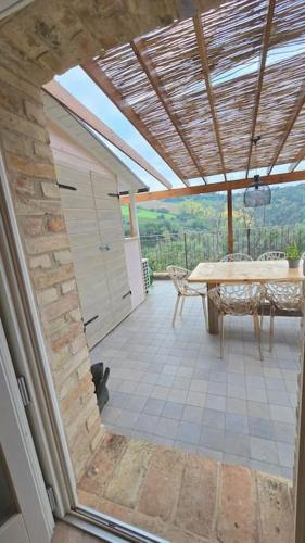 a view of a patio with a table and a roof at The Cherry House, Apartamento Monterosa in Petritoli