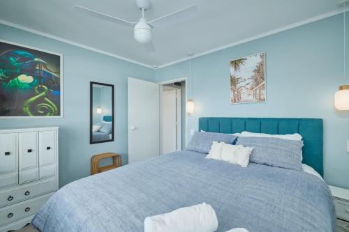 a blue bedroom with a bed and a blue wall at Cosy Private Home in South Bay in Kaikoura