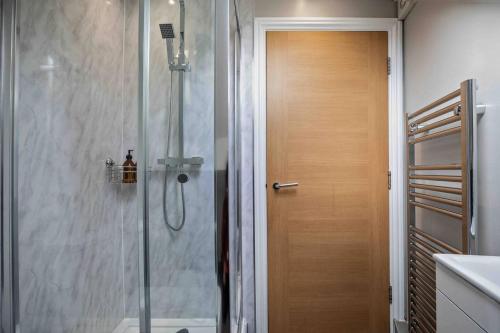 a shower with a glass door in a bathroom at Stylish & Spacious 3 Bed Apartment With Parking in Sheffield