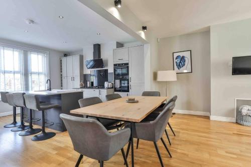 a kitchen and dining room with a wooden table and chairs at Stylish & Spacious 3 Bed Apartment with Parking in Sheffield