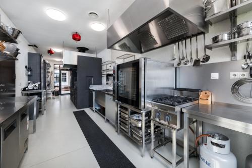 a large commercial kitchen with stainless steel appliances at Woodland Retreat Lodge in Vallapalu