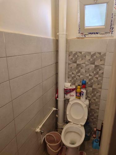 a small bathroom with a toilet and a window at Draria درارية in El Achour